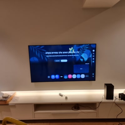 טלוויזיה מותקנת על קיר עם מדף תחתון