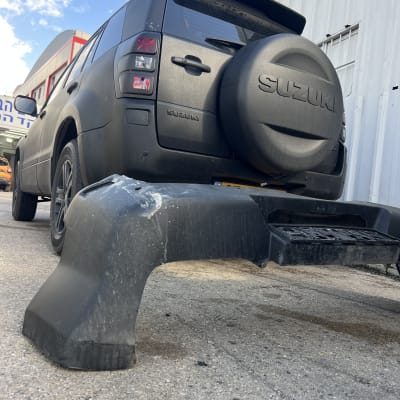 רכב סוזוקי עם פגוש פגום בחניה