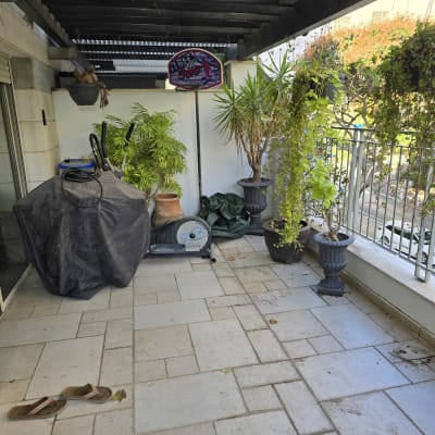 מרפסת עם רצפת אריחים, עציצים וציוד מכוסה