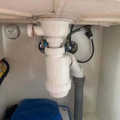 צנרת מתחת לכיור עם חיבורים וצינורות