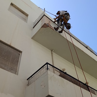 עובד בגובה על מרפסת עם ציוד בטיחות