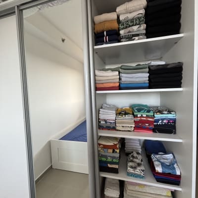 ארון בגדים מסודר עם בגדים מקופלים על מדפים