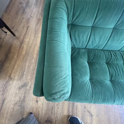 ספה ירוקה על רצפת עץ עם כבל חשמלי צהוב