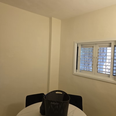 קיר צבוע וחלון בחדר עם שולחן עגול