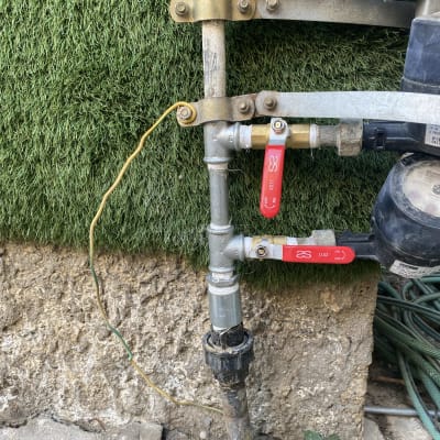 צינורות מים עם ברזים אדומים על קיר חיצוני