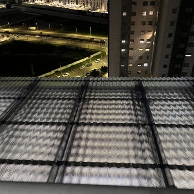 גג מתכת עם נוף עירוני בלילה