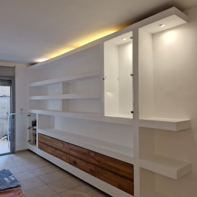 מדפים לבנים עם תאורה עליונה בחדר ריק