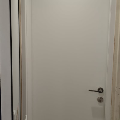 דלת לבנה עם ידית מתכת בחדר מואר