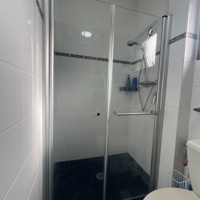 מקלחון זכוכית עם ראש מקלחת ומדף סבונים