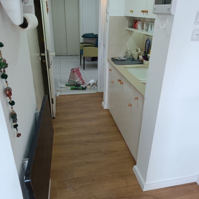 רצפת פרקט עץ במסדרון ביתי עם קיר לבן