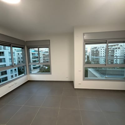 חדר ריק עם חלונות גדולים ונוף עירוני