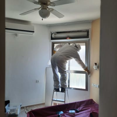 אדם בחליפת מגן על סולם ליד חלון