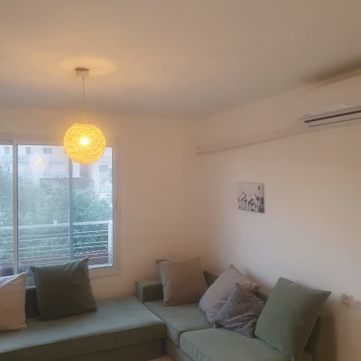 חדר עם ספה ירוקה ותאורה תלויה