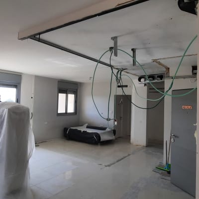 חוטי חשמל תלויים מהתקרה, רהיטים מכוסים בניילון