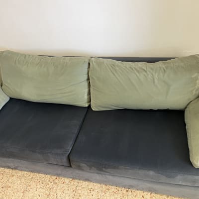 ספה עם כריות ירוקות על רצפת אריחים