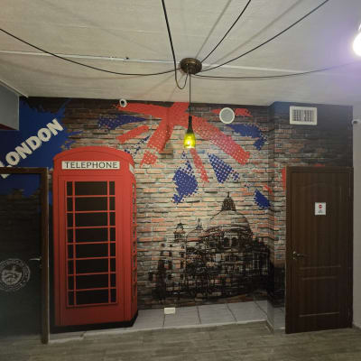 קיר עם ציור תא טלפון אדום ודגל בריטי