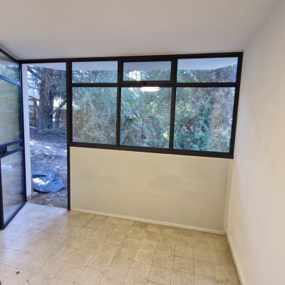 חלון ודלת אלומיניום בחדר ריק עם סולם