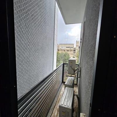 רשת הגנה מותקנת על מרפסת למניעת כניסת יונים