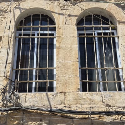 התקנת חלונות אלומיניום לבנים בפתחים קשתיים במבנה אבן