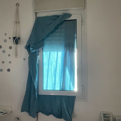 תריסים סגורים עם וילון כחול על חלון