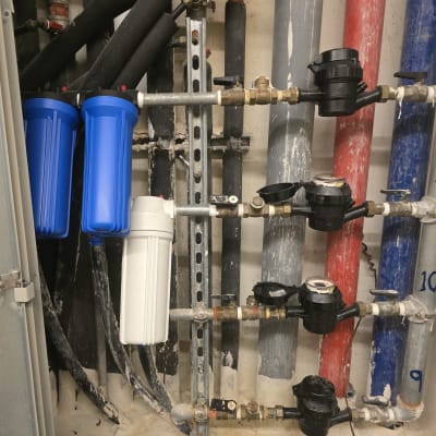 מערכת צינורות ומסננים כחולים בעבודת אינסטלציה