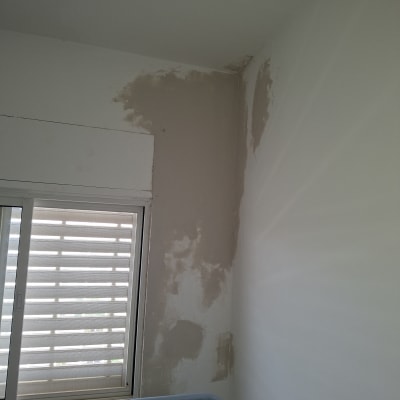 תיקון קיר עם טיח ליד חלון
