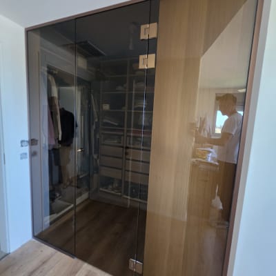 ארון עם דלתות זכוכית כהות בחדר שינה