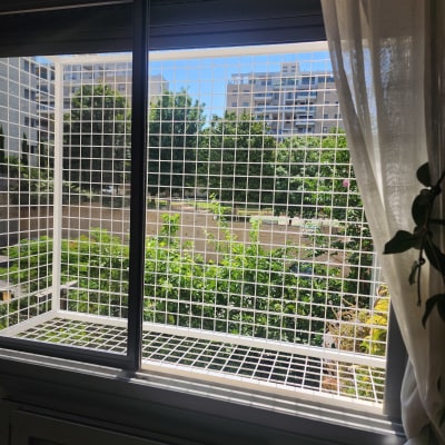 חלון עם סורג מתכת מרובע וילון לבן בצד