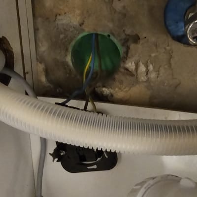 חוטי חשמל יוצאים מקופסה ירוקה בקיר