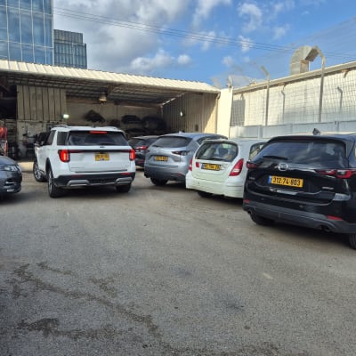 מכוניות חונות ליד מוסך עם ציוד חשמלי לרכב