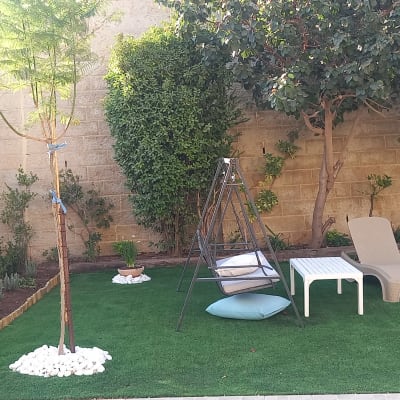 גינה עם דשא סינתטי, עצים וריהוט גן