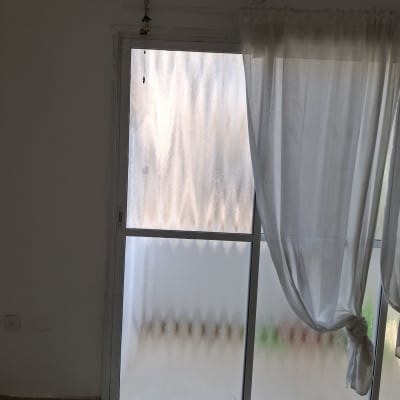 חלון זכוכית עם וילון לבן קשור בצד