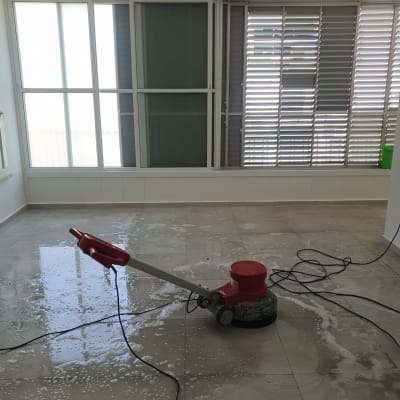 מכונת פוליש אדומה על רצפה רטובה עם סבון