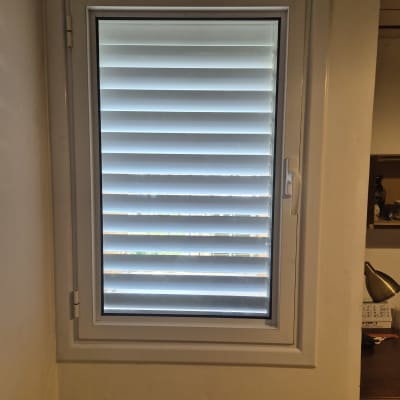 חלון עם תריסים אלומיניום בחדר פנימי