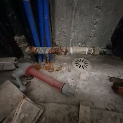 צינורות וכלים בתחום האינסטלציה על רצפה מלוכלכת