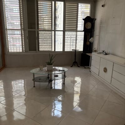 חדר ריק עם חלונות גדולים ושעון עומד