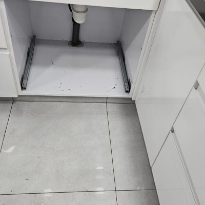 כיור מטבח עם צינור ניקוז מתחת לארון