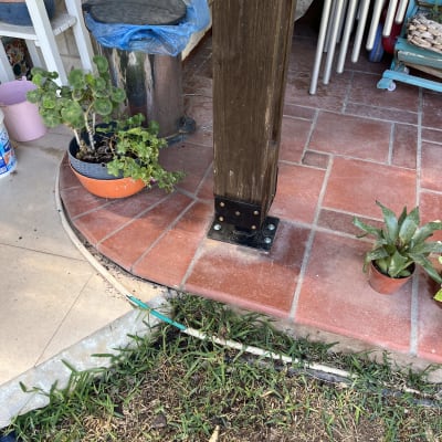 עמוד עץ על רצפת מרפסת עם עציצים מסביב