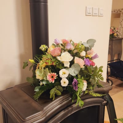 סידור פרחים צבעוני על תנור ברזל שחור