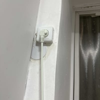 שקע חשמלי עם כבל מחובר לקיר לבן