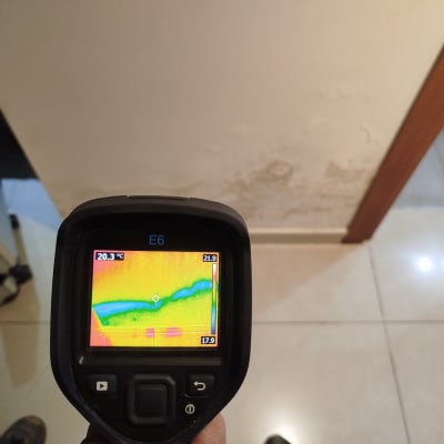 מד חום תרמי מציג נזילה בקיר