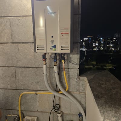 מחמם מים מותקן על קיר עם צינורות חיבורים