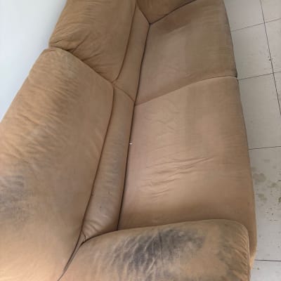 ספה מלוכלכת עם כתמים כהים על הריפוד