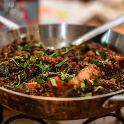 תבשיל בשר עם עשבי תיבול במחבת מתכת