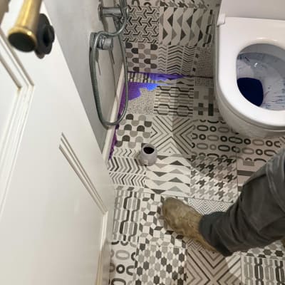 רגל של אינסטלטור ליד אסלה עם נזילה