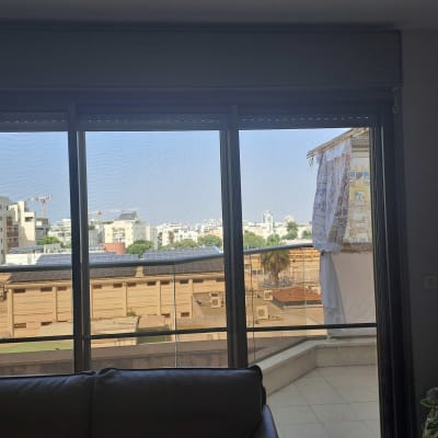 תריסים סגורים למחצה על חלון זכוכית גדול