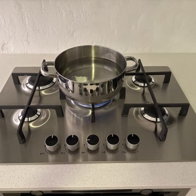 כיריים גז עם סיר מים על להבה