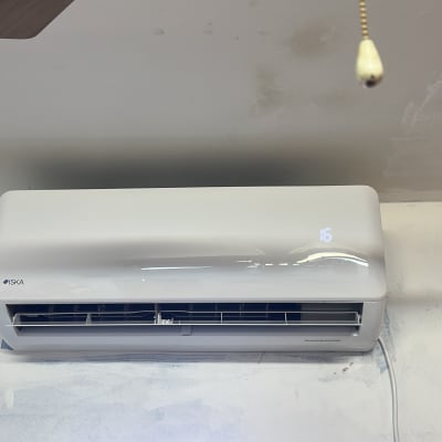 מזגן קיר לבן עם תצוגת טמפרטורה דיגיטלית