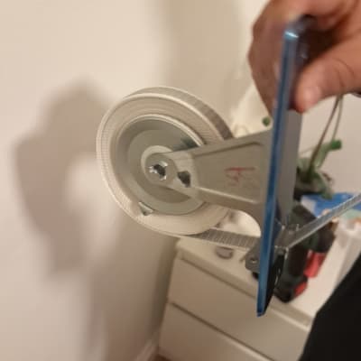 יד מחזיקה כלי עבודה עם גלגלת ליד קיר