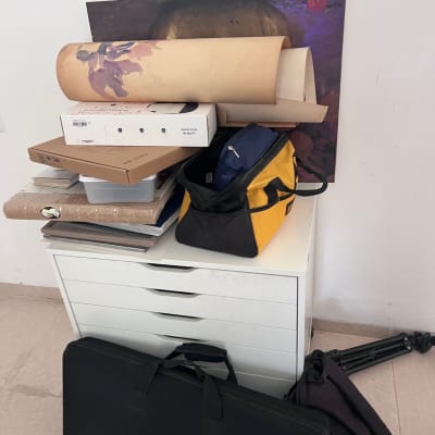 תיקי נשיאה וציוד על שידה לבנה